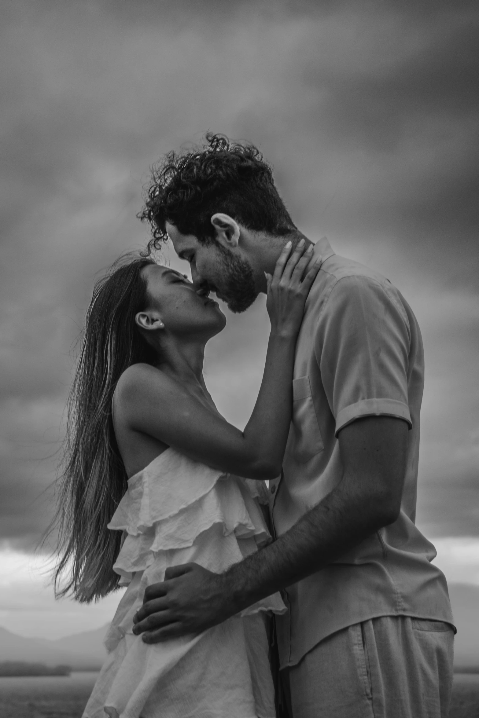 an image of man kissing a woman on the beach