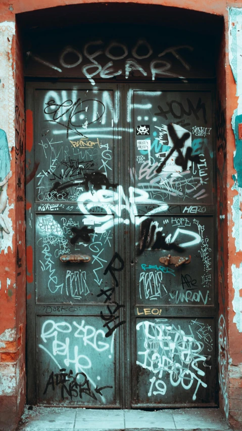 graffiti and spray paint are adorn the entrance to an old door