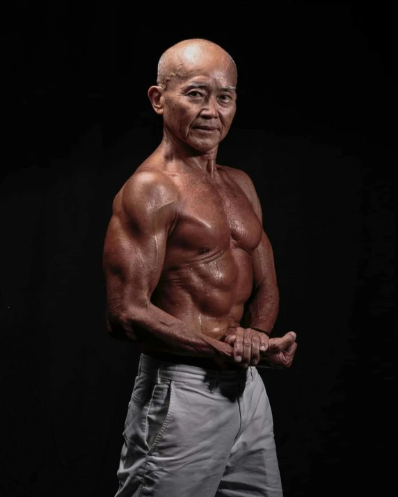 an elderly man poses in front of a black background