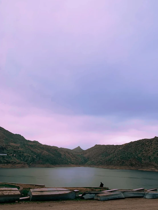 several boats on a small area with mountains in the background