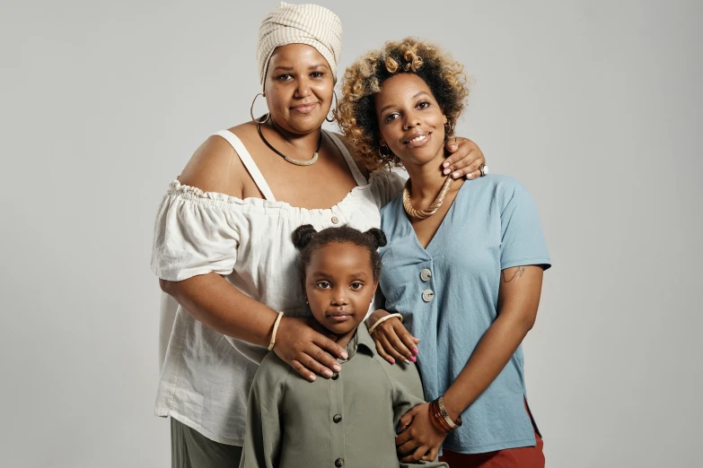 the young lady is posing with her mother and sister