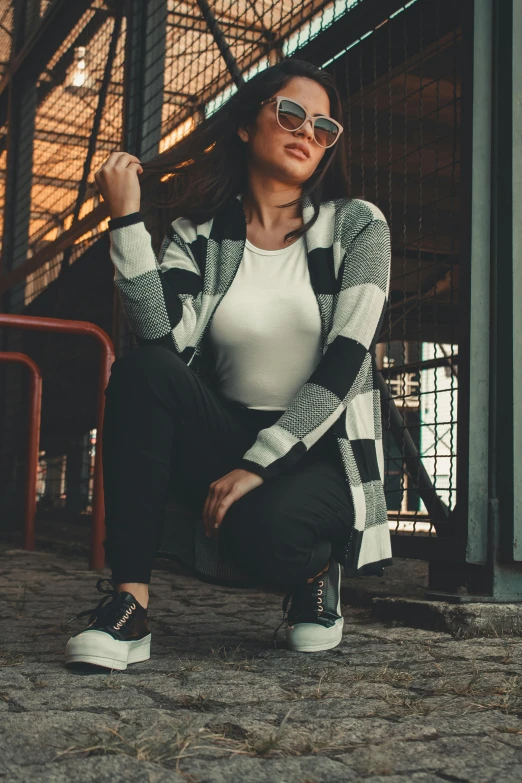 a girl sitting on a pile of dirt next to a metal structure