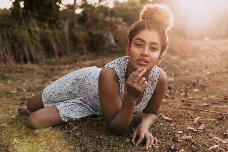 woman laying on the ground in park during sunlight exposure