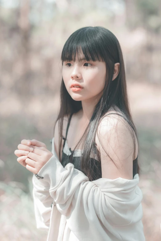 an asian woman with long hair and black bangs poses in a white dress