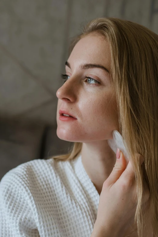 a woman with long hair combing her hair with an electronic device