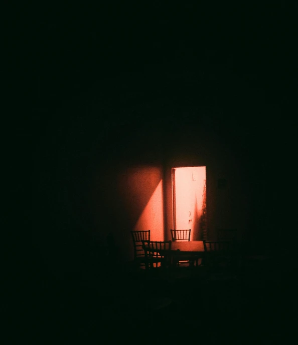 chairs and table are shown against a wall in dark room