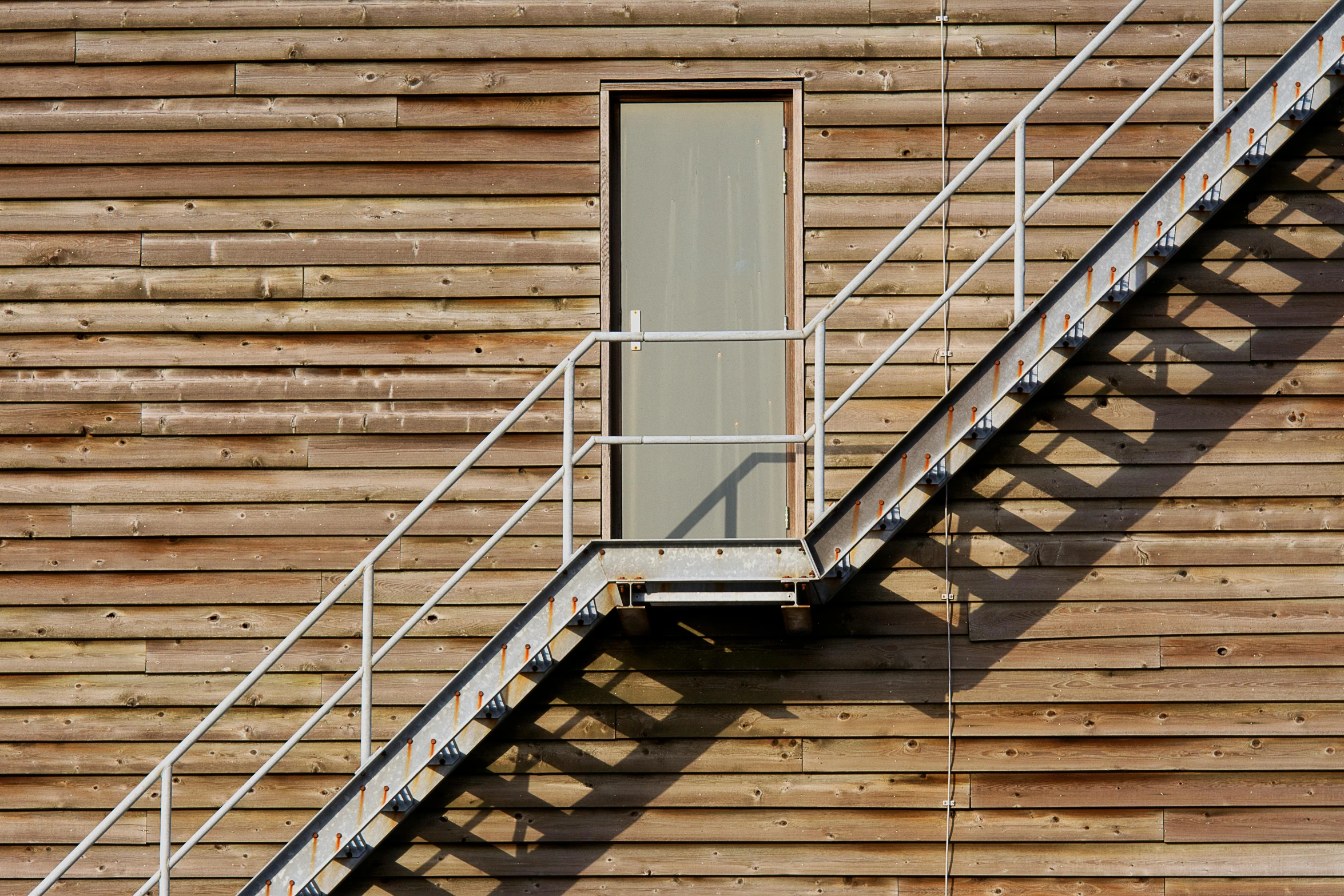 a metal railing with a window next to a wall