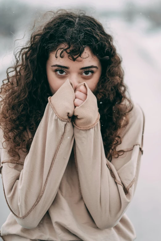 a woman covering her mouth with hand near her face