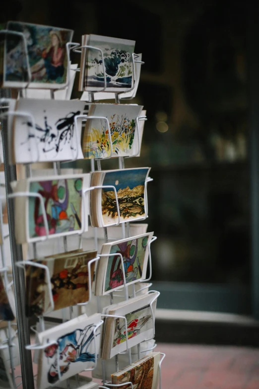 a rack holds many pictures and is hanging on the wall