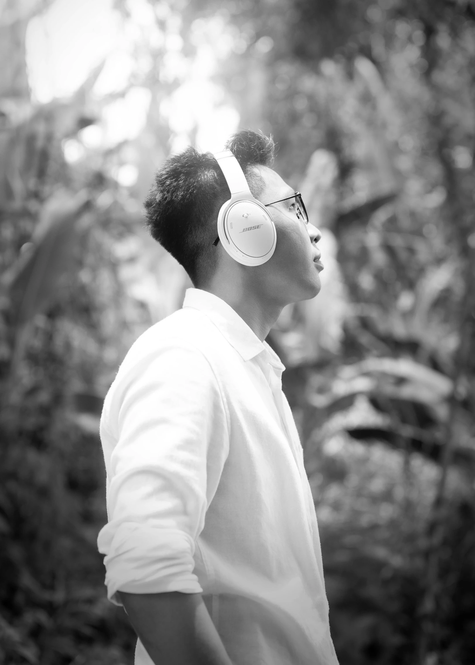 a man wearing ear phones looking at trees