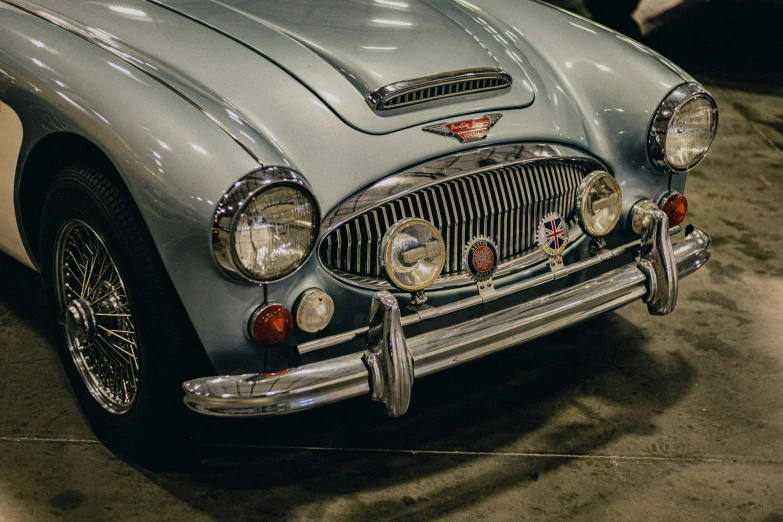 a classic car parked in a garage with the hood up