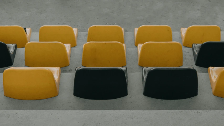 rows of yellow and black chairs sitting on a pavement