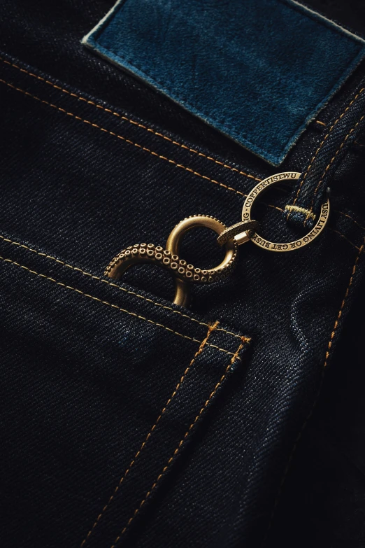 a gold chain on a dark blue jeane