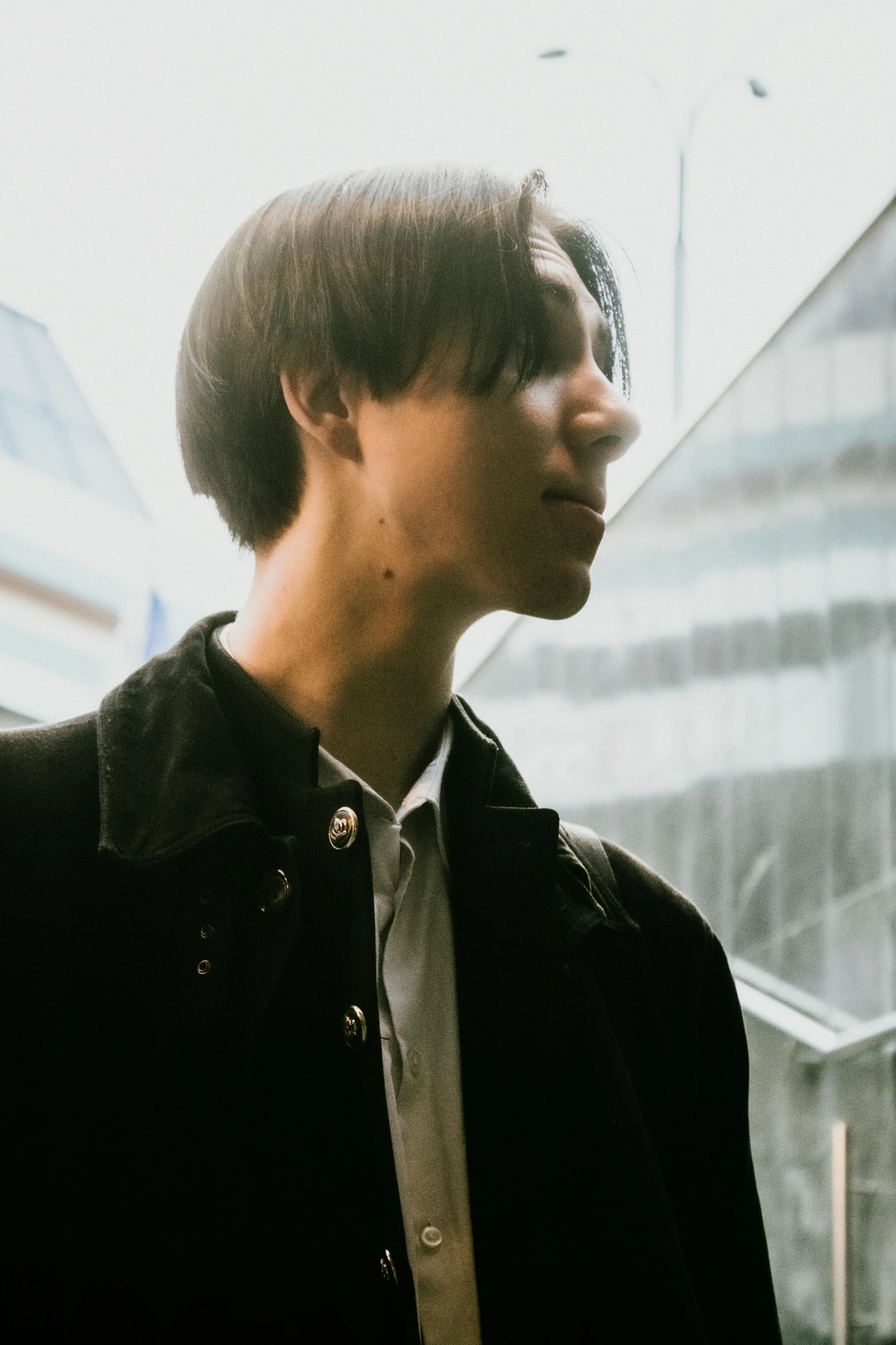 a close - up of a young man in a black jacket looking to the side