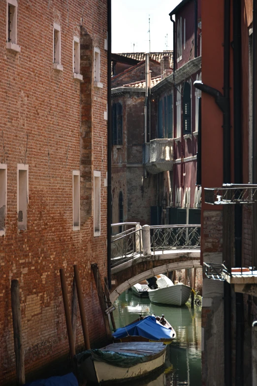 a canal with boats floating down it's sides and a bridge above it