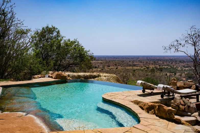 there is an outdoor swimming pool surrounded by large rocks