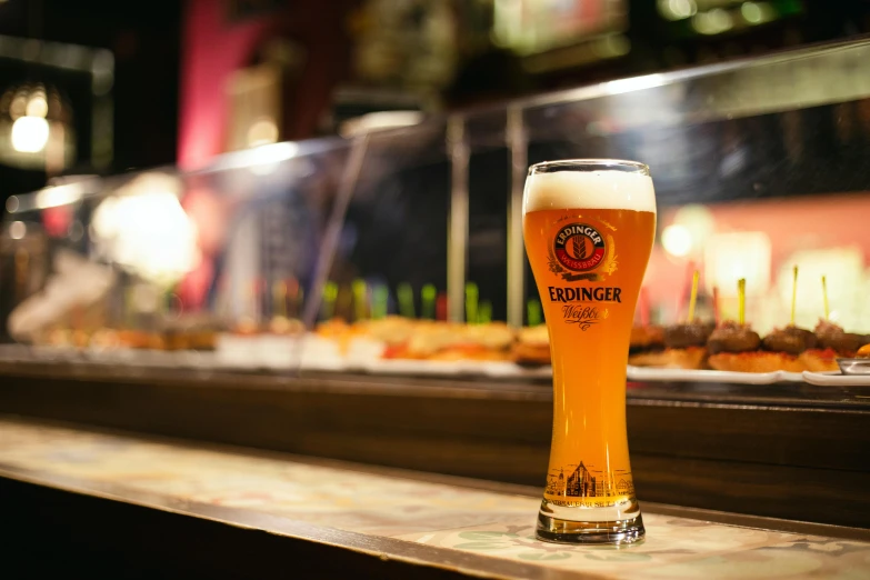 a large pint of beer sitting on a bar