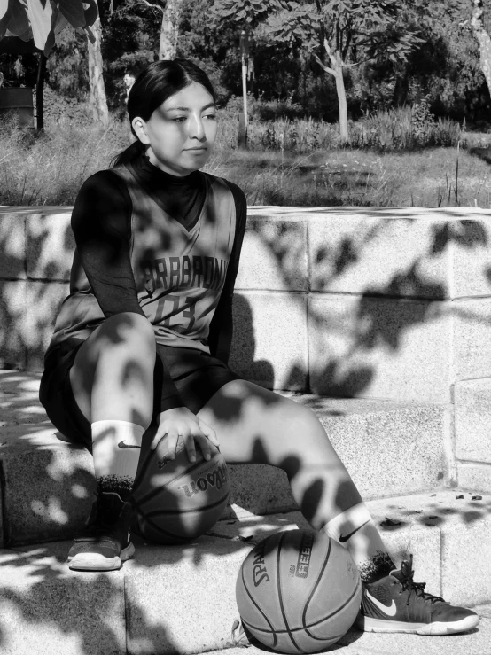 a lady that is sitting down with a basketball