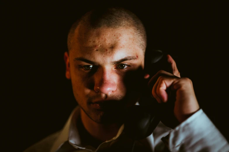 a man is talking on the phone while holding it up to his ear