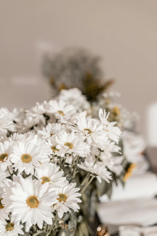 a white vase is filled with flowers on the desk