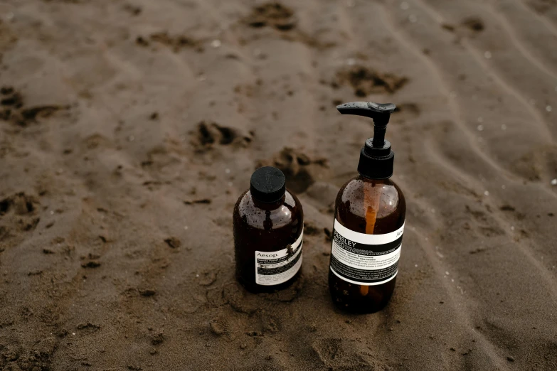 bottle of lotion sitting next to soap dispenser on beach