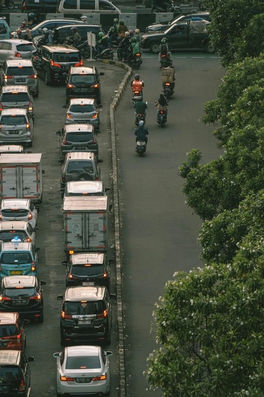 a couple motorcyclists traveling past a long line of traffic