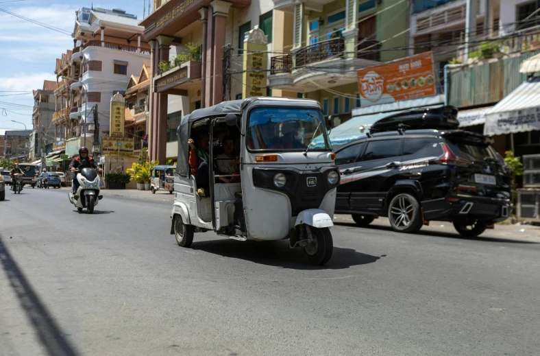 two motorcycles and cars drive down a city street