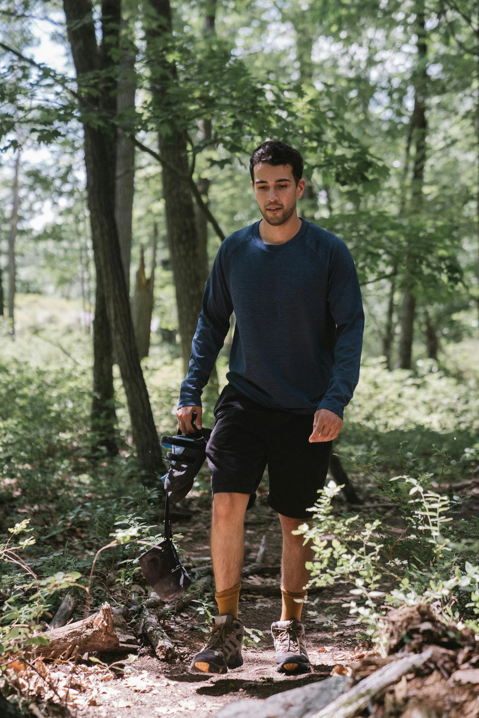 a man in shorts is walking through the woods