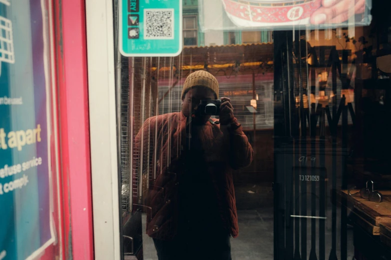 someone taking a picture of themselves through the window