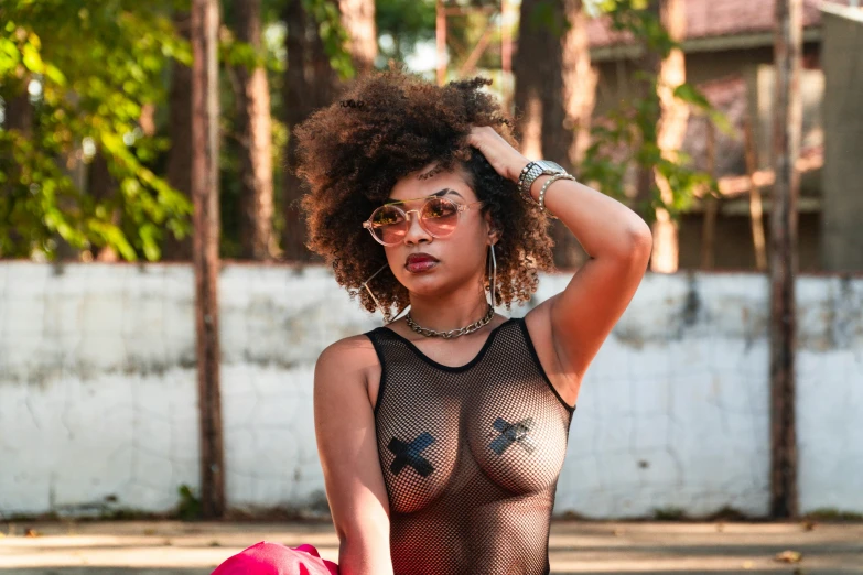a woman with curly hair wearing glasses and a body suit