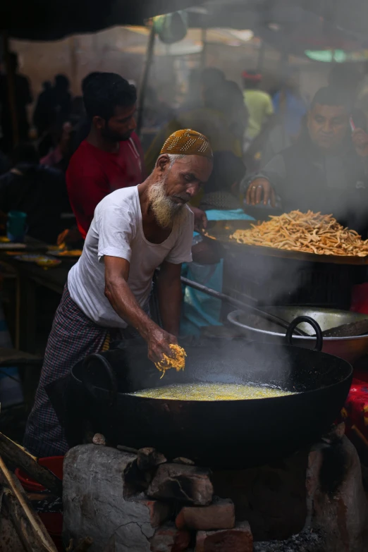 a man is preparing food on a grill in the street