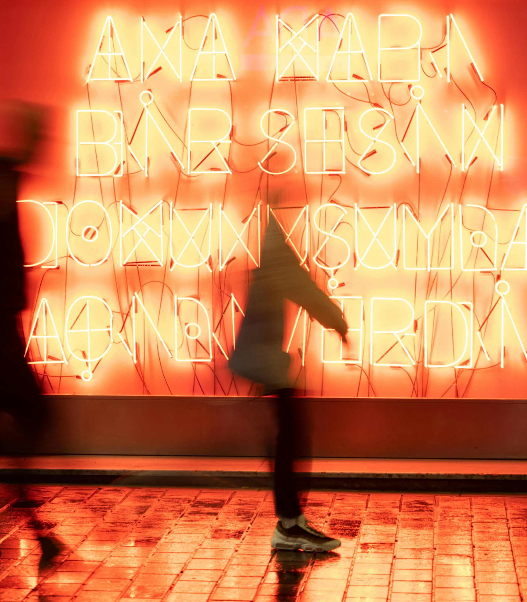 people walking near a neon advertit on the wall