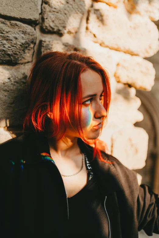 a girl with bright red hair with rainbow markings on her face