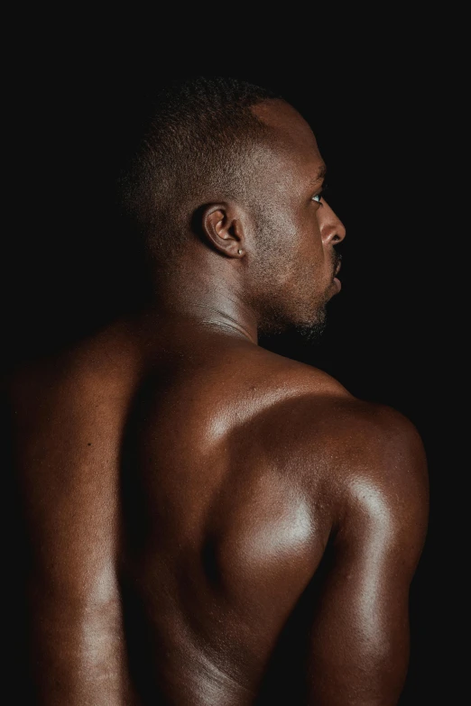 black male  in the dark looking straight ahead