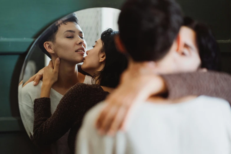 two women in front of a mirror blowing bubbles