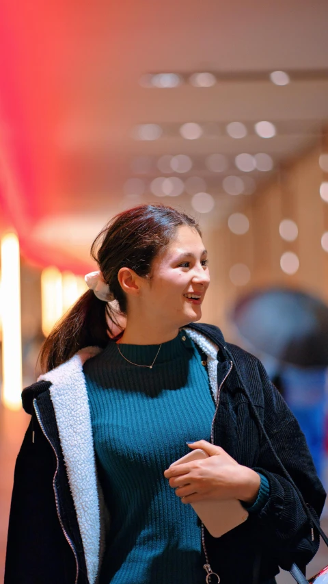  in a large open space with a blue dress smiling