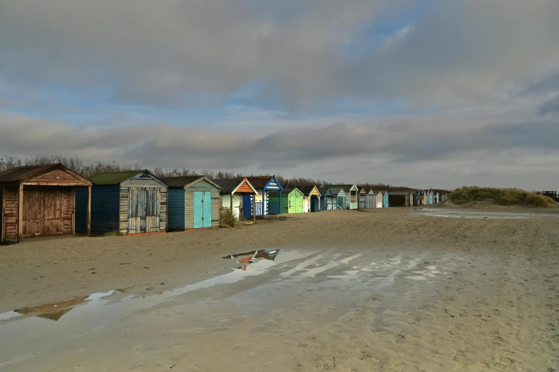 a group of beach huts sitting next to each other on a sandy beach
