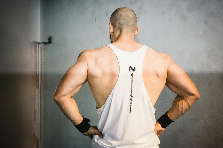 a person standing next to a wall in white shirt