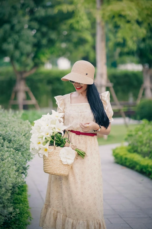 the woman in the hat is carrying flowers