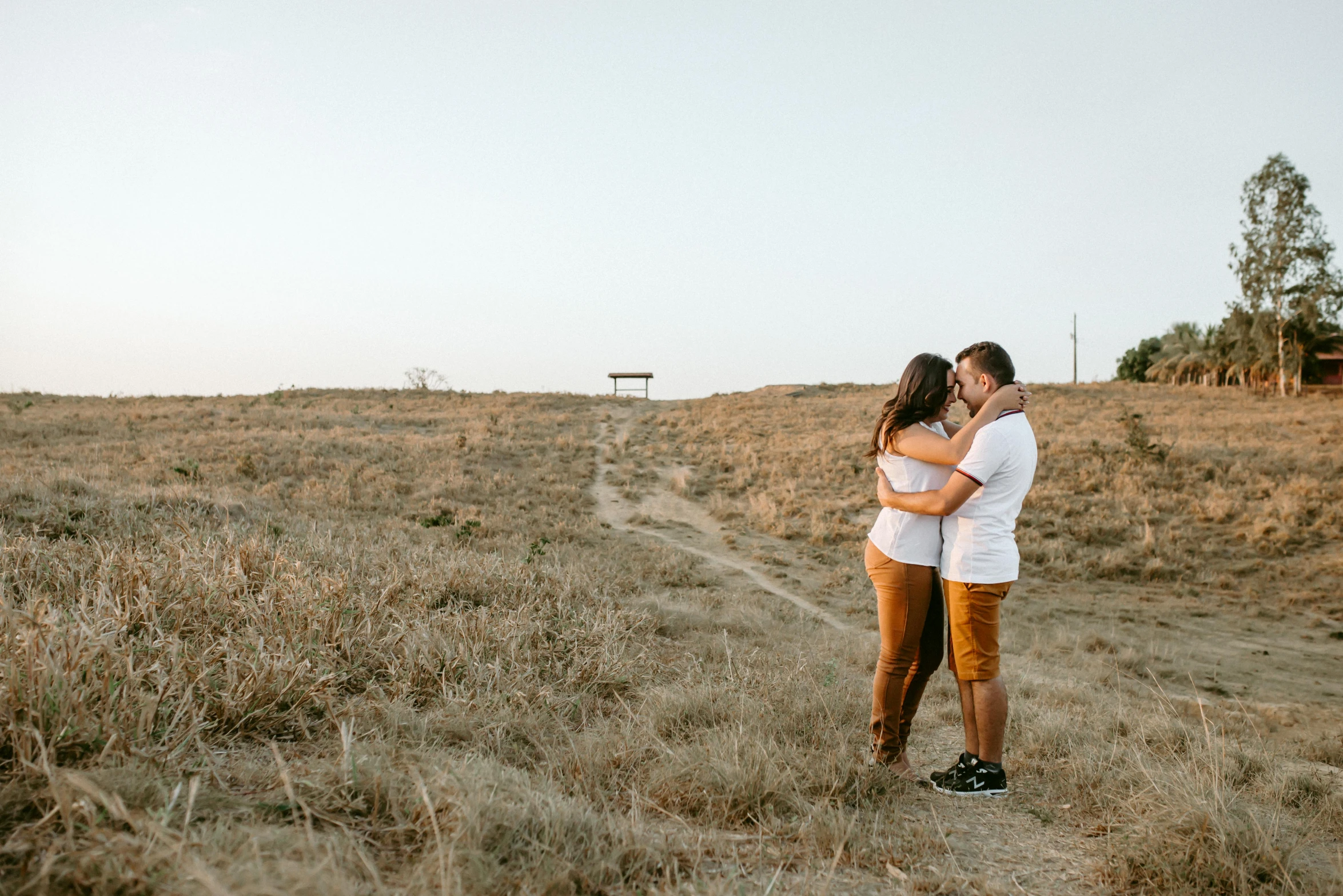 a couple is posing in an open field