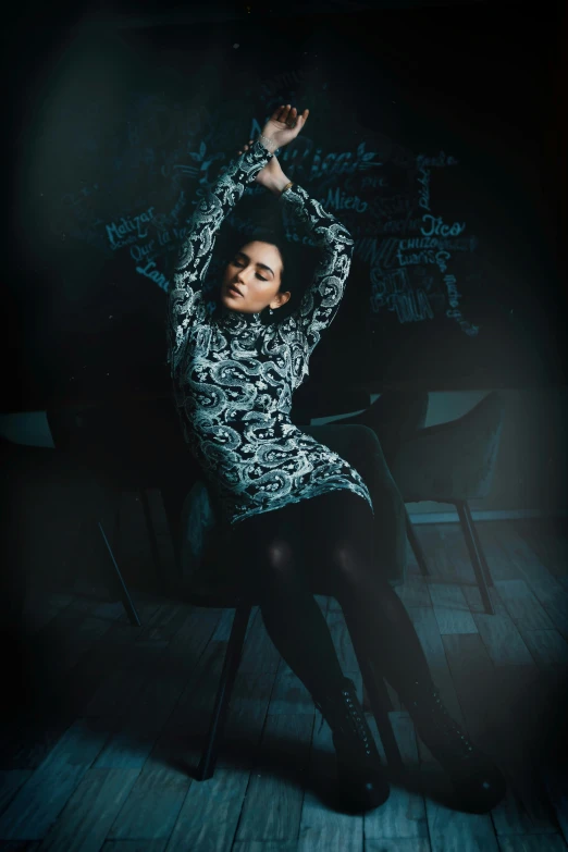 a woman in a black and white dress is sitting on a chair