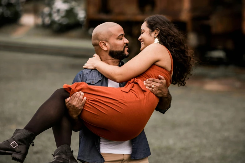 a woman emcing a man as they walk through the grass