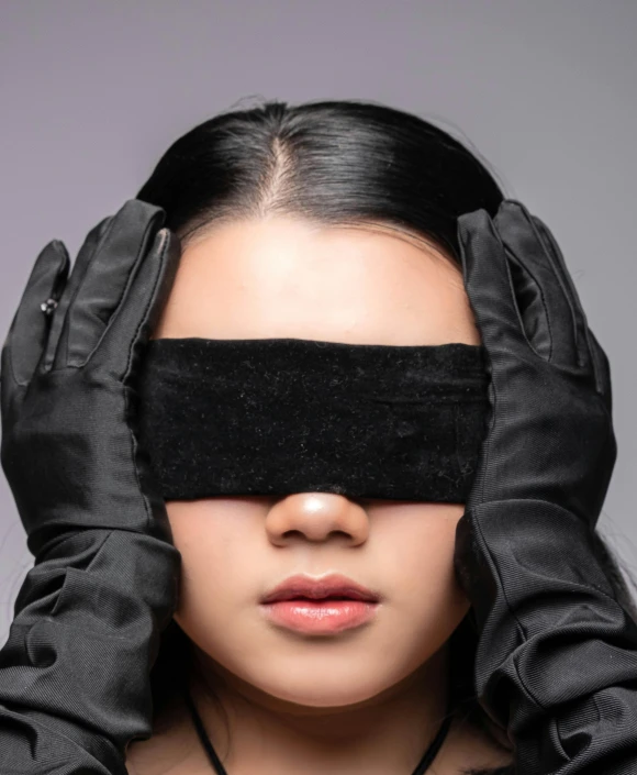 a woman wearing black is covering her eyes