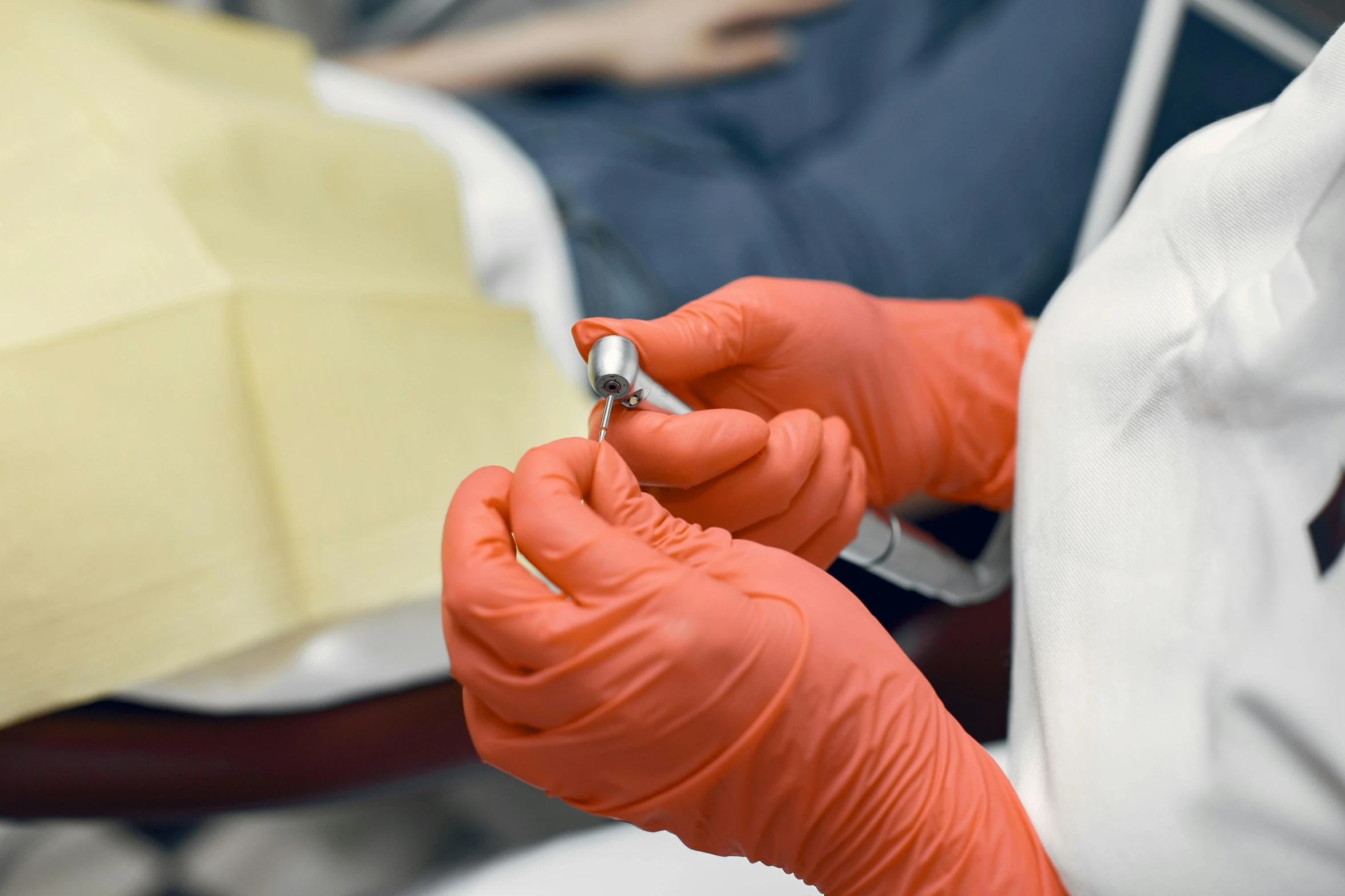 a person in orange rubber gloves holds a piece of soing