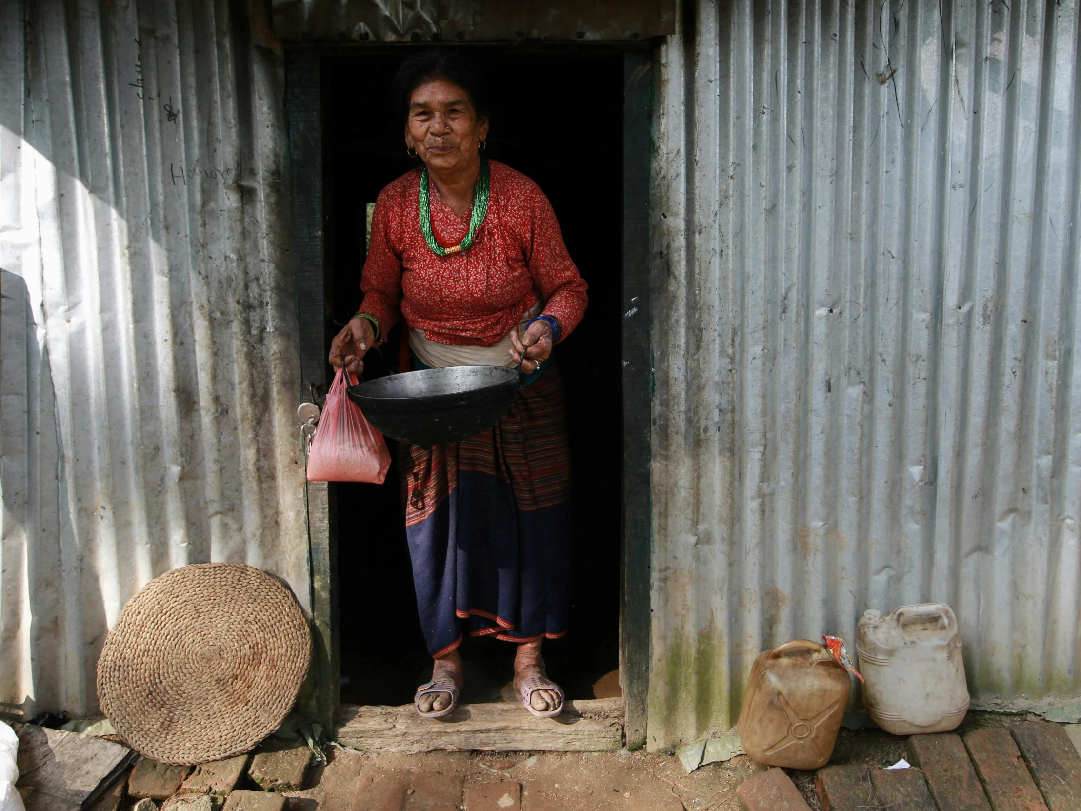 a woman standing on a porch with food and a bucket