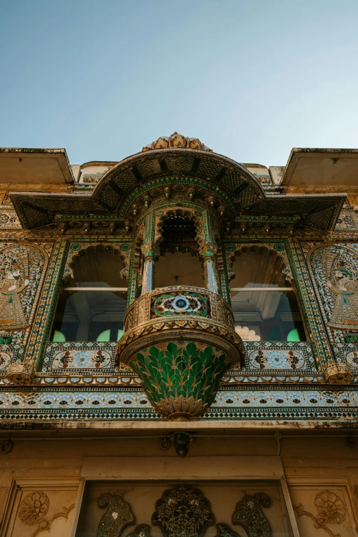 ornate gold and green window above front entry of building