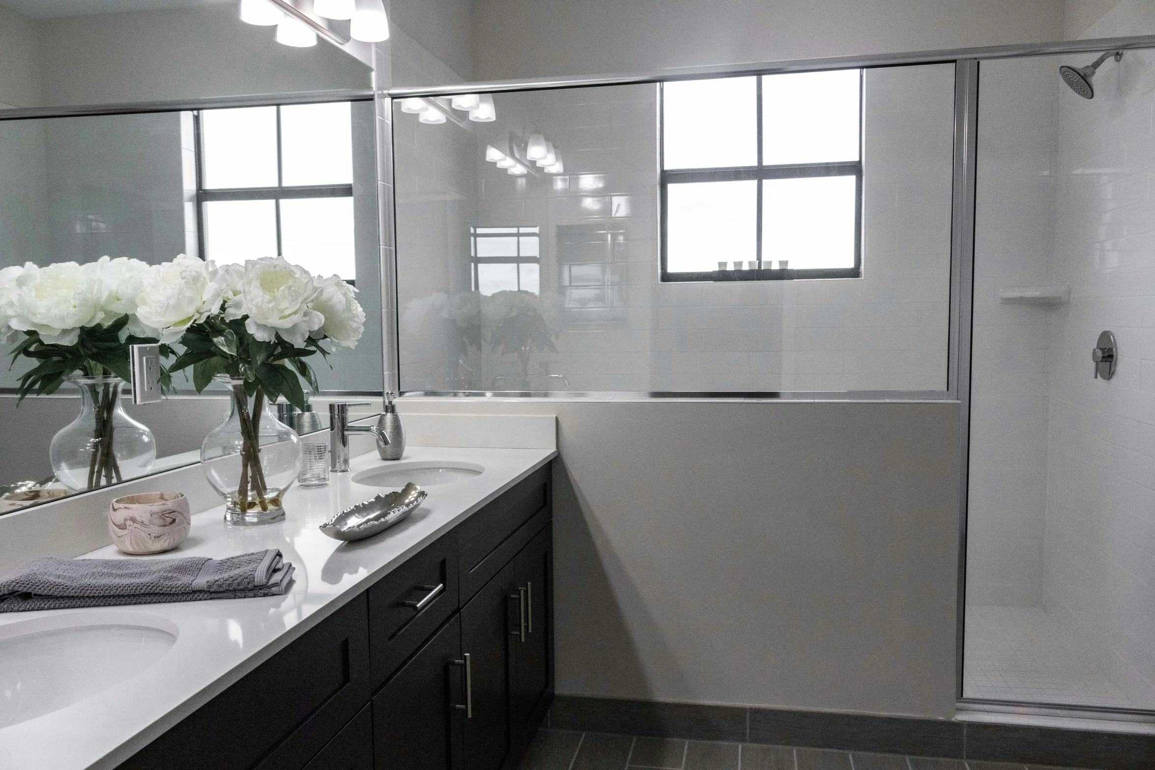 a big white bathroom with flowers and mirrors