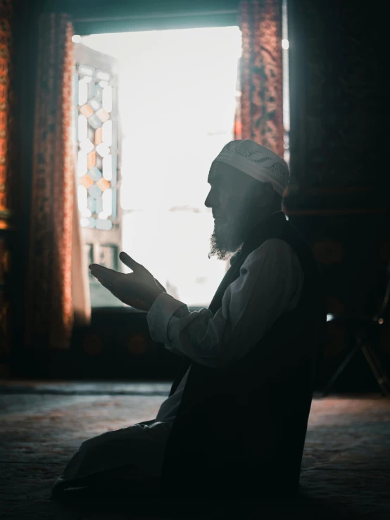 a man sitting on the floor is reading a book