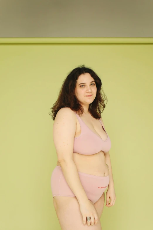 a woman wearing a pink bikini top is posing