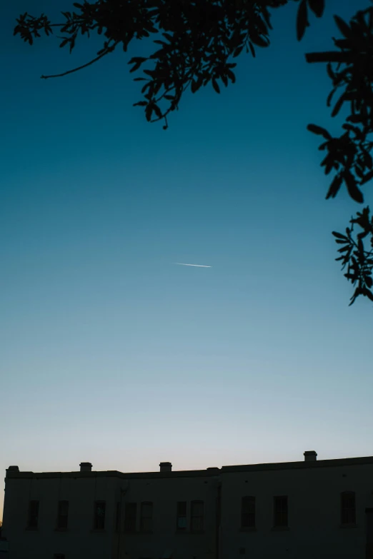 an airplane that is flying through the sky over some buildings